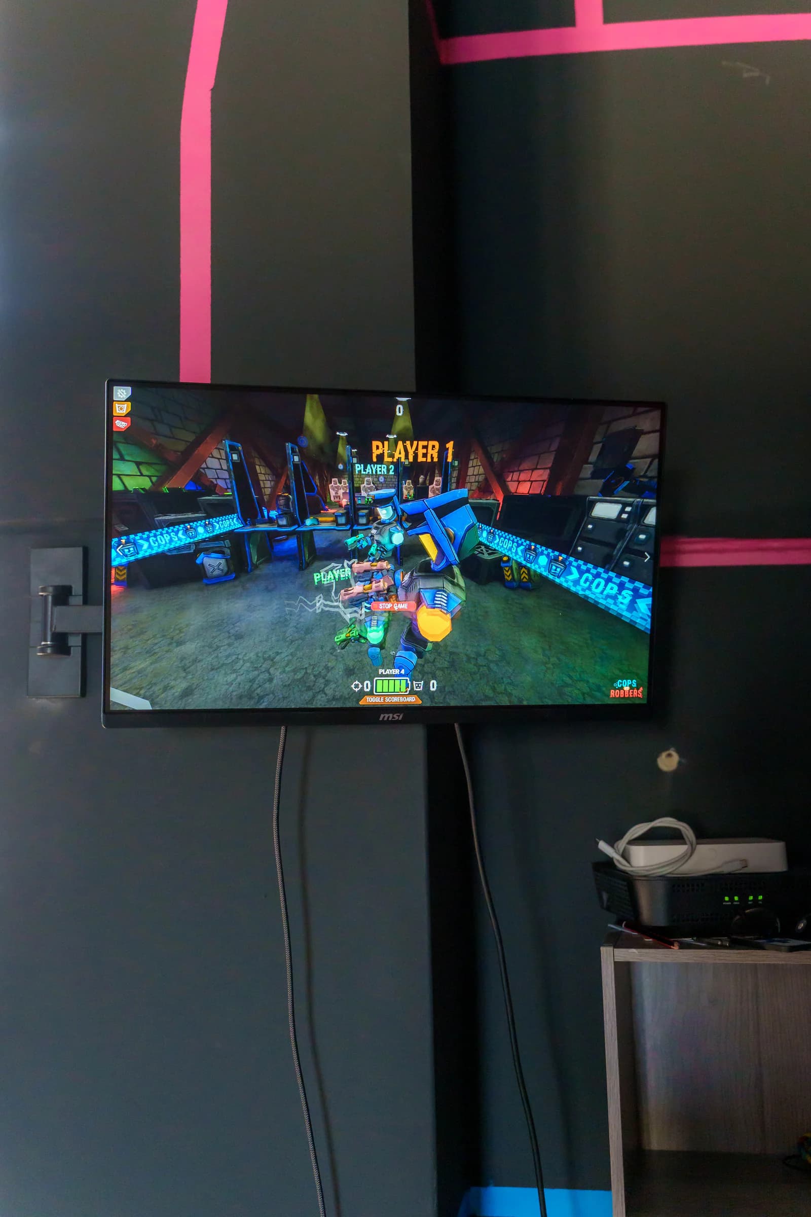 Ecrã na parede da arena a mostrar uma partida de Cops vs Robbers a decorrer